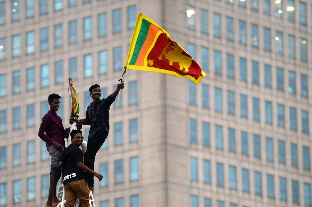 Người biểu tình leo lên tháp gần Văn phòng Thư ký Tổng thống Sri Lanka hôm 11/7, vẫy cờ phản đối chính phủ đương nhiệm giữa khủng hoảng kinh tế - chính trị nghiêm trọng. Ảnh: AFP.
