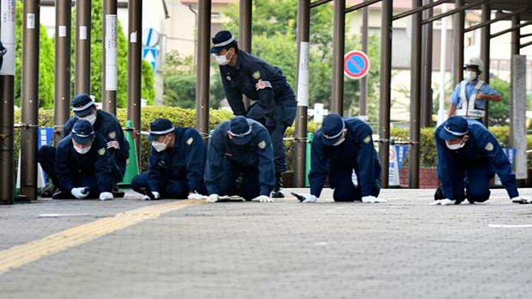 Cảnh sát dàn hàng tìm kiếm đầu đạn tại hiện trường ông Abe bị ám sát ở thành phố Nara, miền tây Nhật Bản ngày 13/7. Ảnh: AP.