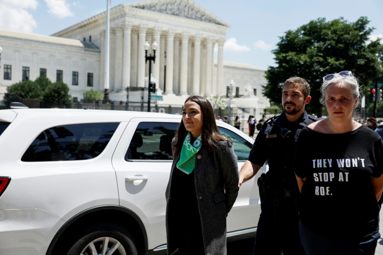 Nghị sĩ Dân chủ Alexandria Ocasio-Cortez (trái) bị cảnh sát áp giải sau khi bị bắt trong cuộc biểu tình trước Tòa nhà Tối cao ở thủ đô Washington ngày 19/7. Ảnh: AFP.