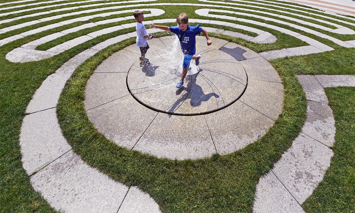 Trẻ em chơi đùa bên vòi phun nước ở thành phố Boston, bang Massachusetts, Mỹ ngày 21/7. Ảnh: AP.