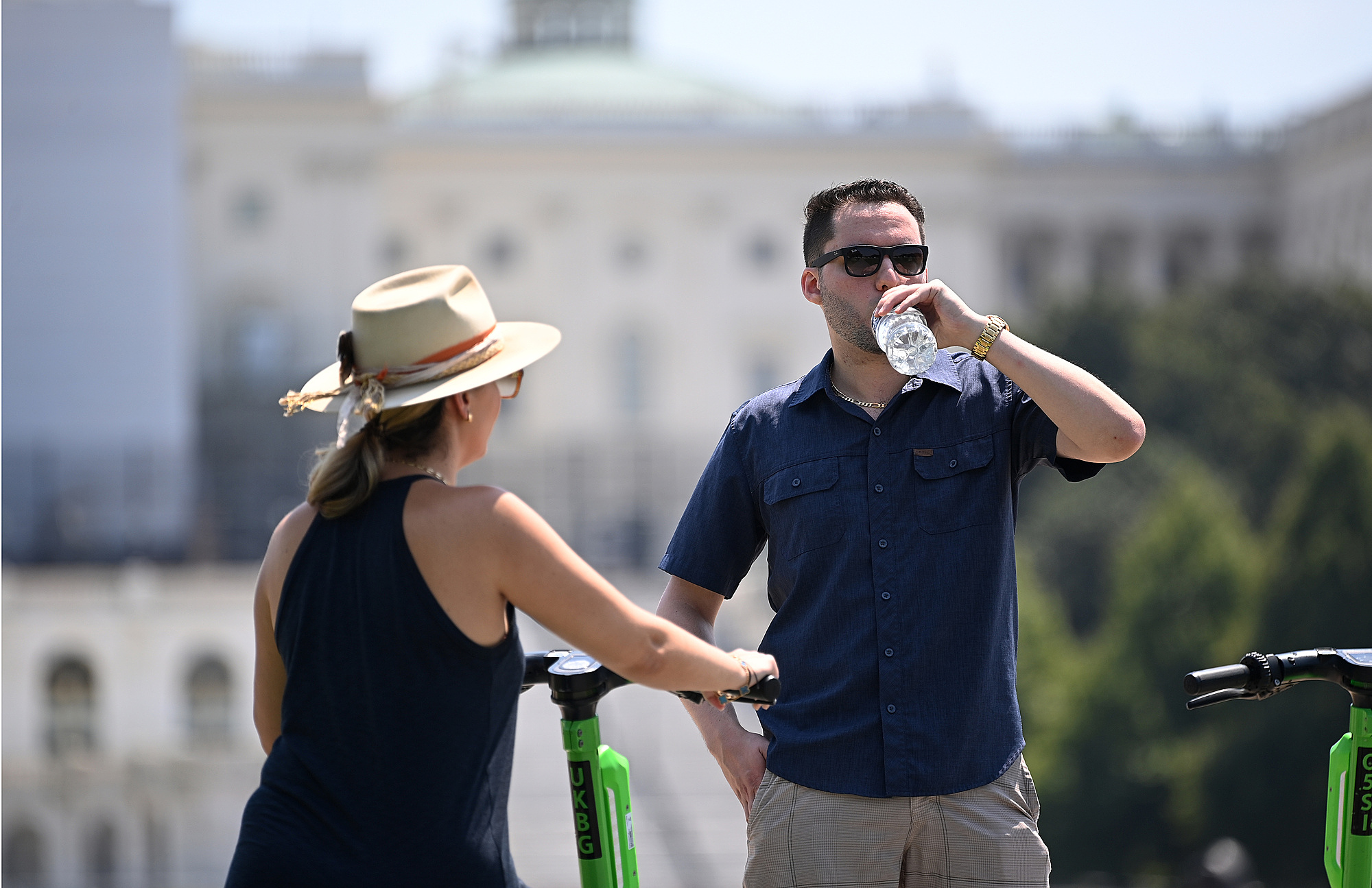 Một cặp đôi uống nước ở Washington D.C., thủ đô Mỹ, ngày 24/7. Ảnh: AFP.