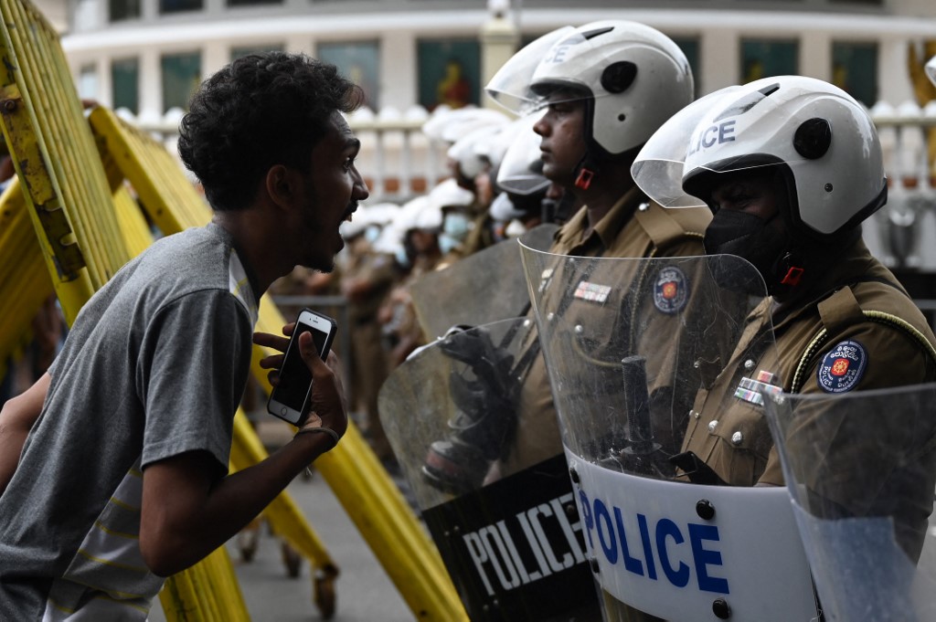 Một người biểu tình tham gia tuần hành phản đối Tổng thống Sri Lanka Ranil Wickremesinghe đối mặt lực lượng cảnh sát đặc nhiệm chặn con đường dẫn tới dinh tổng thống ở Colombo ngày 22/7. Ảnh: AFP