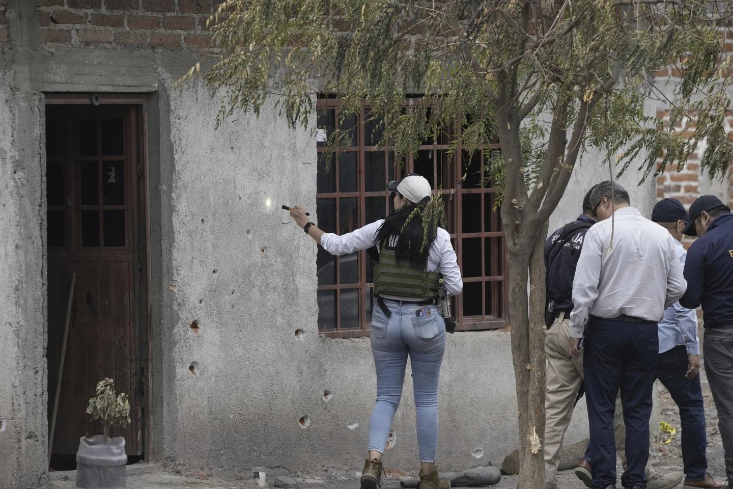 Cảnh sát Mexico khám nghiệm hiện trường vụ xả súng ở La Ruana, ngày 30/6. Ảnh: AP