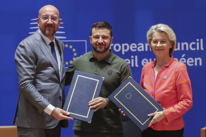 Chủ tịch Hội đồng châu Âu Charles Michel (trái) và Chủ tịch Ủy ban châu Âu Ursula von der Leyen (phải) ký thỏa thuận an ninh với Tổng thống Ukraine Volodymyr Zelensky tại Brussels, Bỉ ngày 27/6. Ảnh: AP