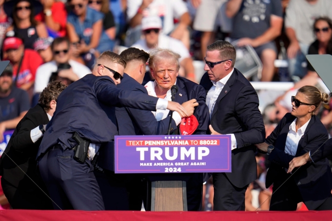 Đội mật vụ đưa ông Trump rời sân khấu  diễn thuyết tại Butler, bang Pennsylvania chiều 13/7. Ảnh: AP