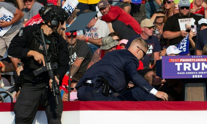 Nhân viên mật vụ Mỹ vây quanh ông Trump sau khi nghi phạm nổ súng hôm 13/7. Ảnh: AFP