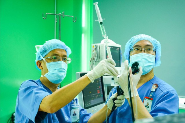 PGS.TS.BS Lê Thượng Vũ (bên trái) đang tiến hành nội soi phế quản siêu âm sinh thiết cho một trường hợp nghi ngờ có khối u ở vị trí khó tiếp cận. (Ảnh bệnh viện cung cấp)