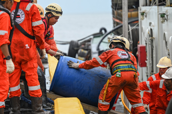 Người Philippines vận chuyển hóa chất xử lý tràn dầu lên thuyền ở Limay, ngày 26/7. Ảnh: AFP