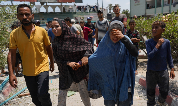 Người tị nạn Palestine rời khỏi trường Khadija sau khi nơi này bị tập kích hôm 27/7. Ảnh: AFP