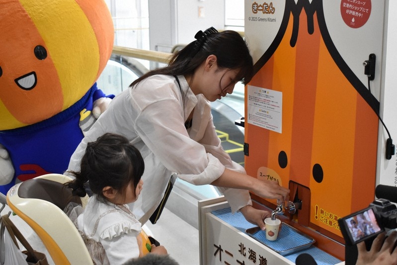 Hành khách ở sân bay Memanbetsu, Hokkaido rót súp hành tây từ vòi ngày 1/7. Ảnh: Mainichi