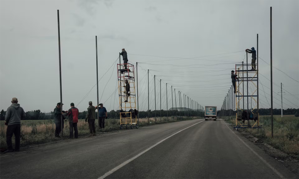 Binh sĩ Ukraine chăng lưới chống drone trên một tuyến đường dẫn tới tiền tuyến ở tỉnh Donetsk ngày 12/6. Ảnh: Le Monde
