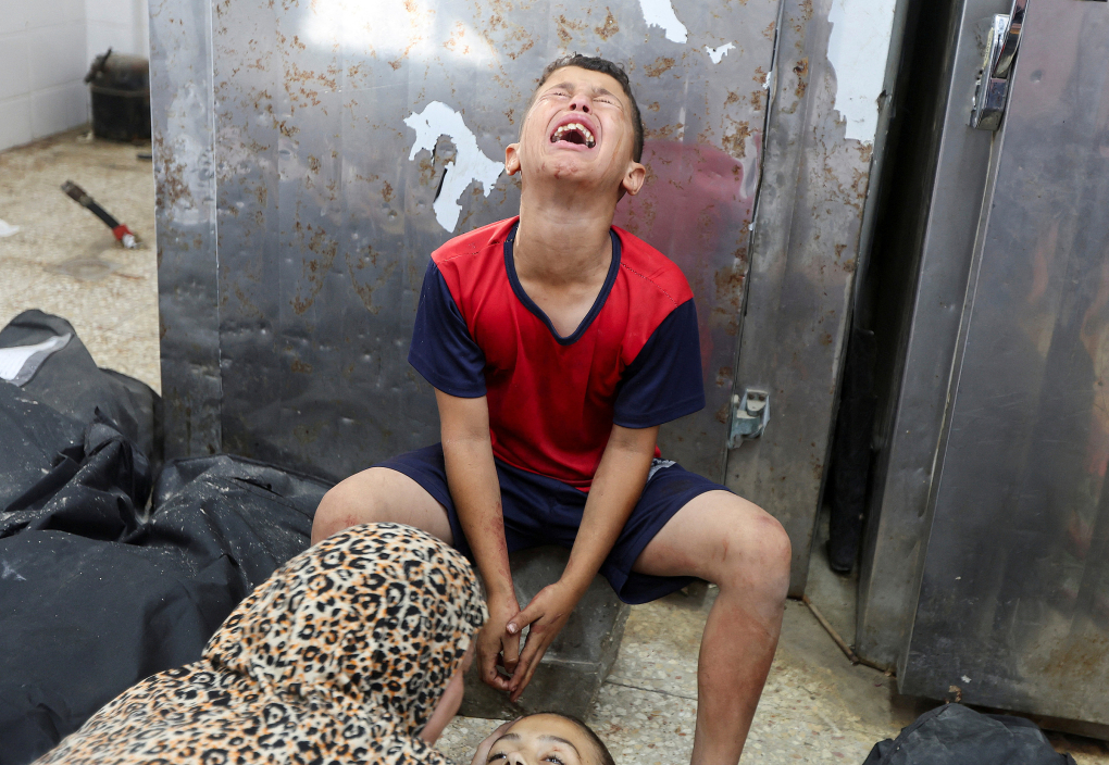 Thiếu niên Palestine khóc thương em gái thiệt mạng trong vụ Israel không kích đám đông xếp hàng trước trạm xá ngày 10/7. Ảnh: Reuters