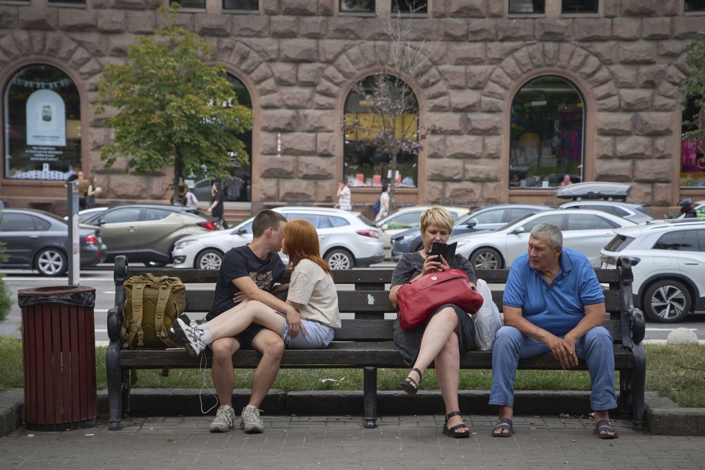 Người dân ngồi nghỉ trên ghế đá giữa trung tâm Kiev ngày 9/7. Ảnh: AP