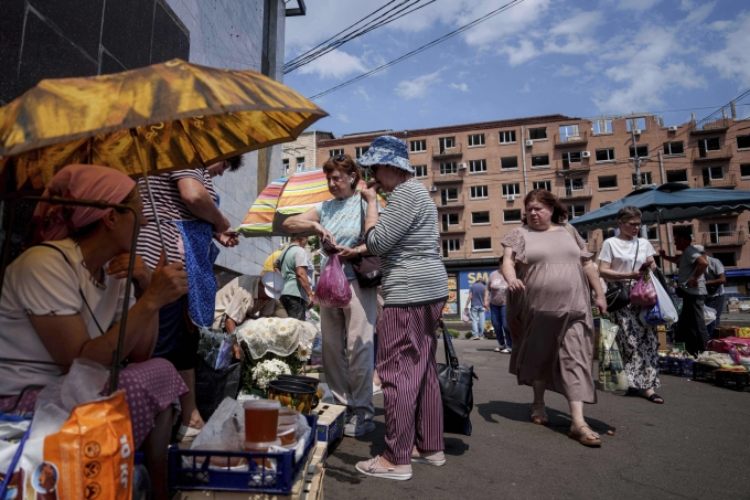 Cảnh mua bán ở khu chợ cóc gần một tòa chung cư trúng tên lửa Nga ở Kiev ngày 10/7. Ảnh: AP