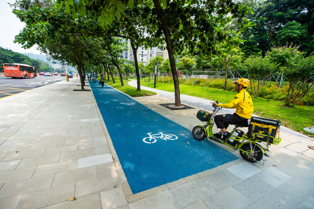 Một tài xế giao hàng bằng xe điện hai bánh lưu thông trên đường Kiều Hương ở Thâm Quyến. Ảnh: Reuters