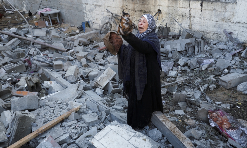 Người phụ nữ đứng giữa đống đổ nát tại hiện trường một cuộc không kích của Israel ở Rafah, phía nam Dải Gaza, tháng 2/2024. Ảnh: Reuters