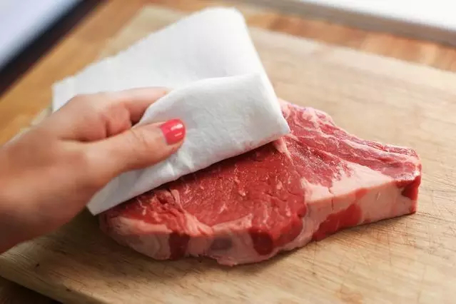 Dùng giấy ăn kiểm tra thịt lợn có bị bơm nước hay không. Ảnh: Aboluowang