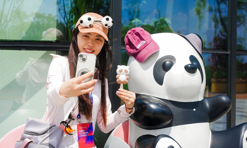 Một nữ du khách chụp hình với tượng gấu trúc tại Thành Đô, Tứ Xuyên vào tháng 5. Ảnh: Trip