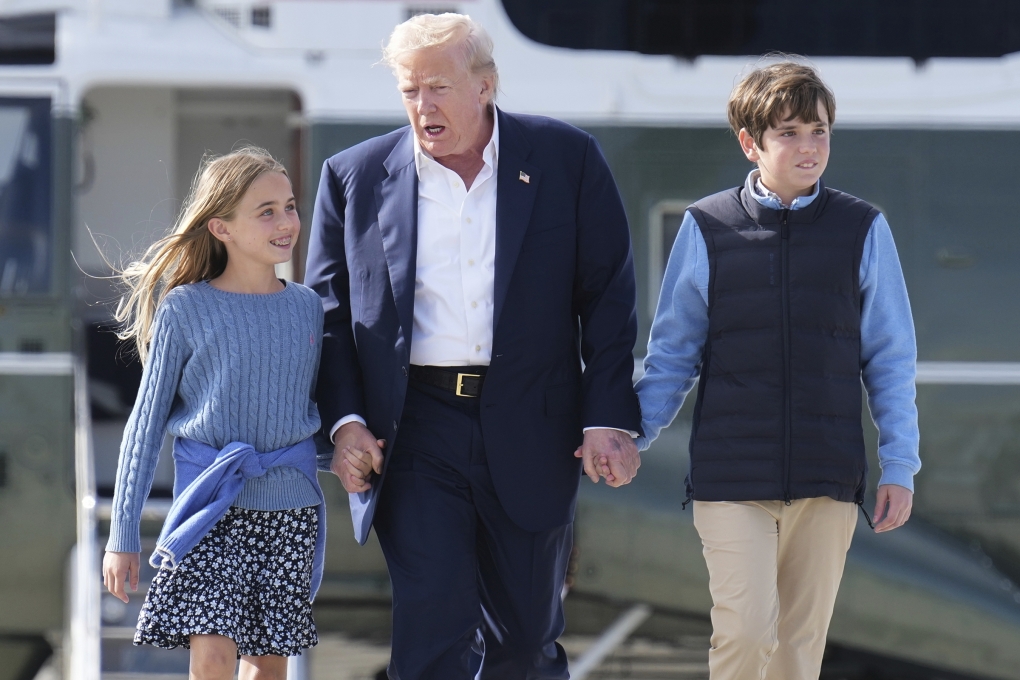 Ông Trump dắt tay hai cháu nội Chloe và Spencer, chuẩn bị lên chuyên cơ Không Lực Một ở Scotland ngày 29/7. Ảnh: AP