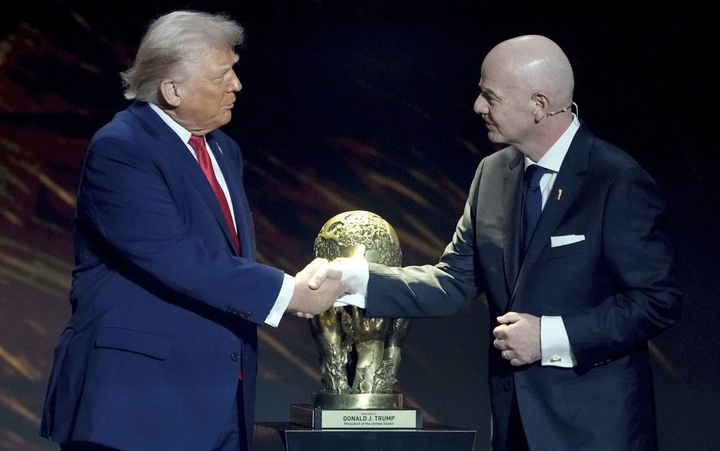 Tổng thống Trump (trái) bắt tay Chủ tịch FIFA Gianni Infantino trong lễ bốc thăm vòng bảng World Cup 2026 tại Trung tâm Kenedy, Washington, Mỹ, hồi tháng 12/2025. Ảnh: AP