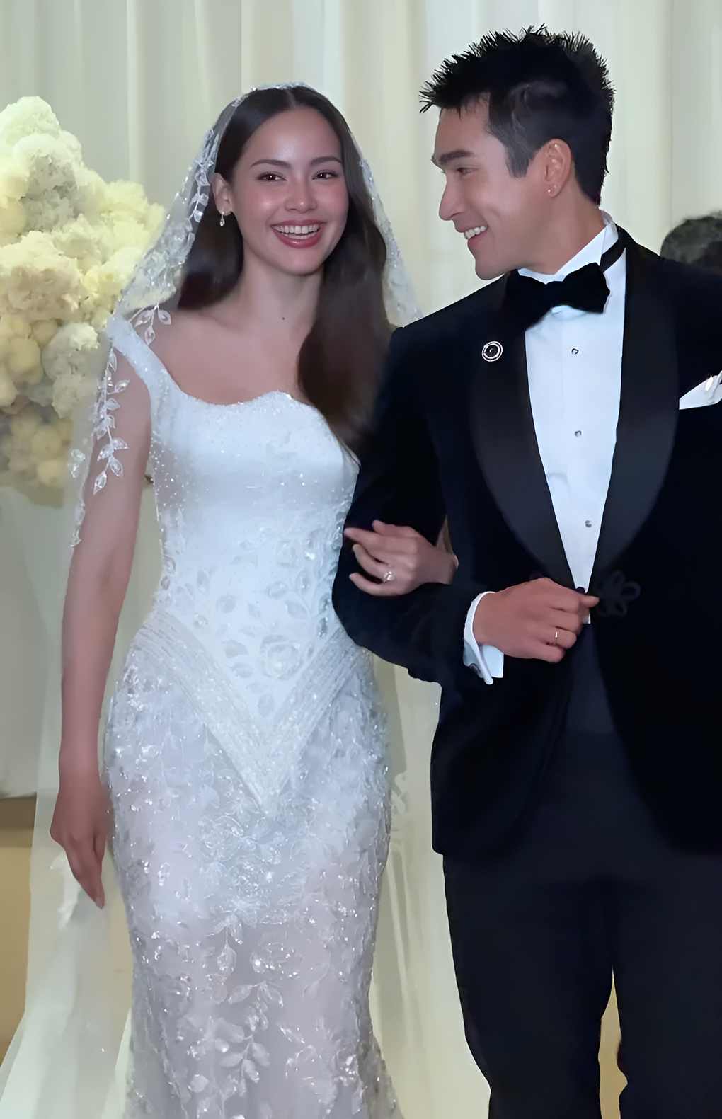 Bộ trang phục thứ ba phục vụ cho lễ chính và phần chụp ảnh với khách mời. Thiết kế vẫn giữ được phong cách lộng lẫy cho Yaya-Urassaya Sperbund. Chiếc váy cúp ngực có phần cổ vuông bo tròn với thiết kế cong mềm mại. Toàn bộ trang phục được đính kết bằng những viên pha lê và hạt cườm lấp lánh dưới ánh sáng. Chân váy kiểu đuôi cá được làm từ ren voan mỏng, tạo thêm nét gợi cảm. Khăn voan được làm từ vải tuyn nhẹ, viền ren hoa, hài hòa với các chi tiết của váy.