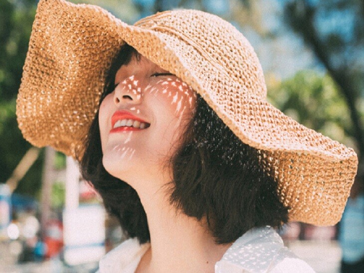 Chủ động sử dụng mũ rộng vành che chắn cho mái tóc khi dạo biển.