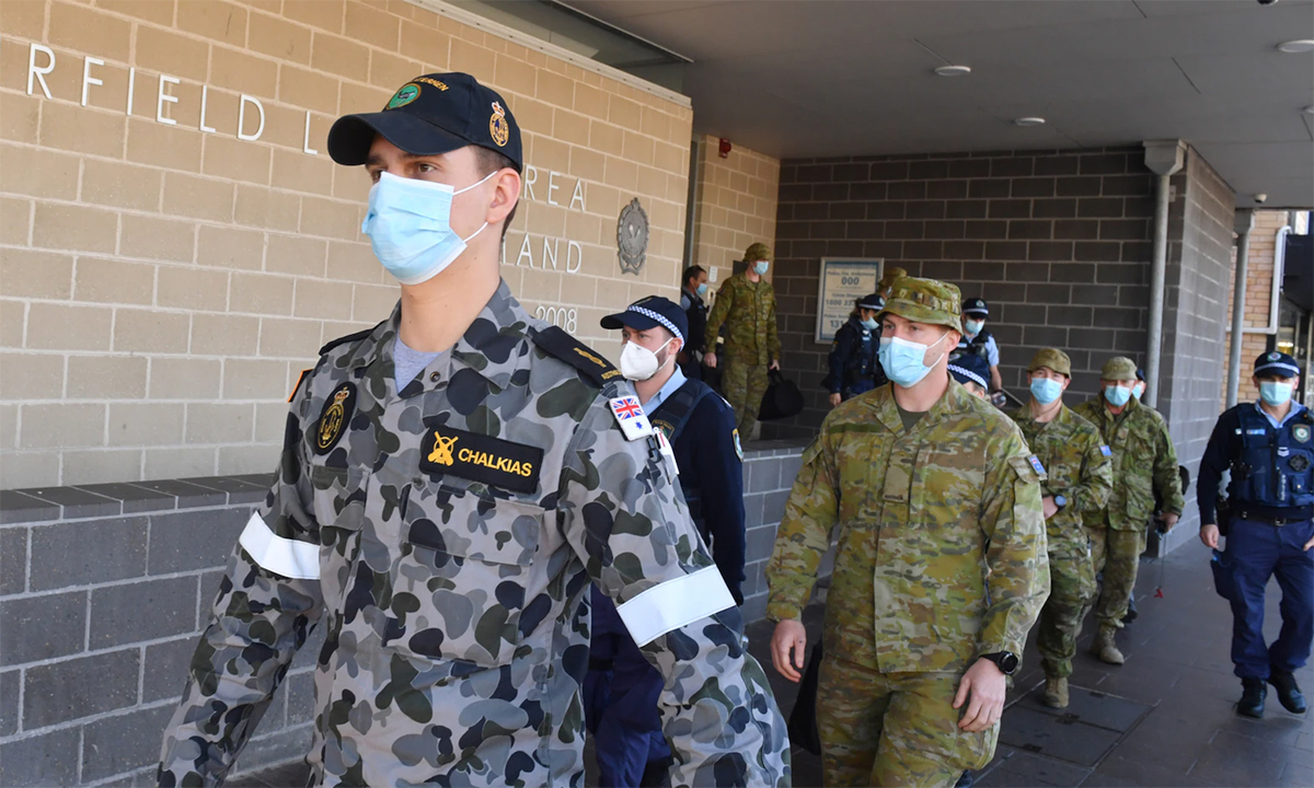 Binh sĩ và cảnh sát Australia bước ra từ đồn cảnh sát Fairfield ở vùng ngoại ô phía tây nam Sydney ngày 2/8. Ảnh: Reuters.