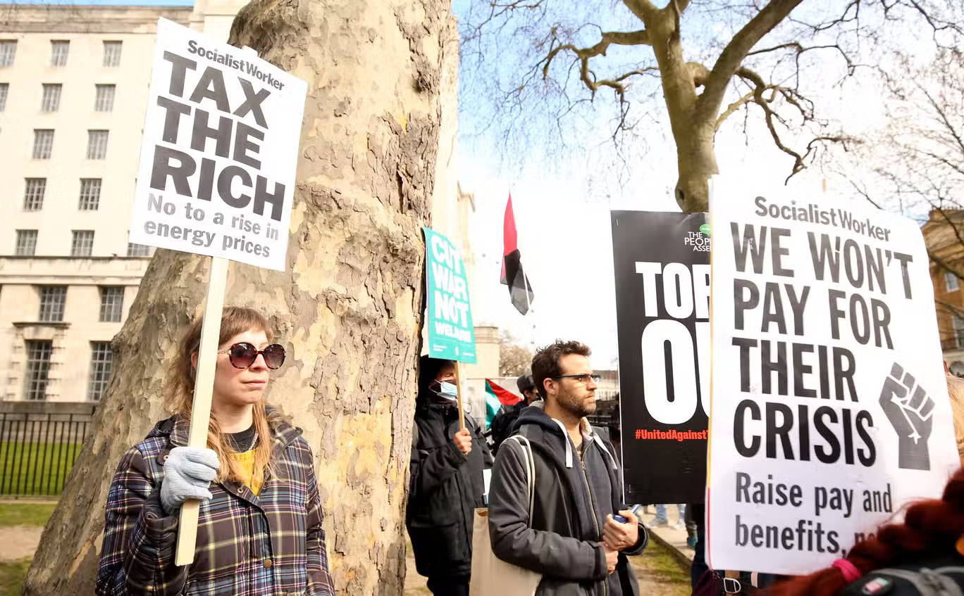 Những người biểu tình cầm biểu ngữ Chúng tôi không trả tiền cho cuộc khủng hoảng của họ tại London, thủ đô Anh, ngày 2/4. Ảnh: Independent.