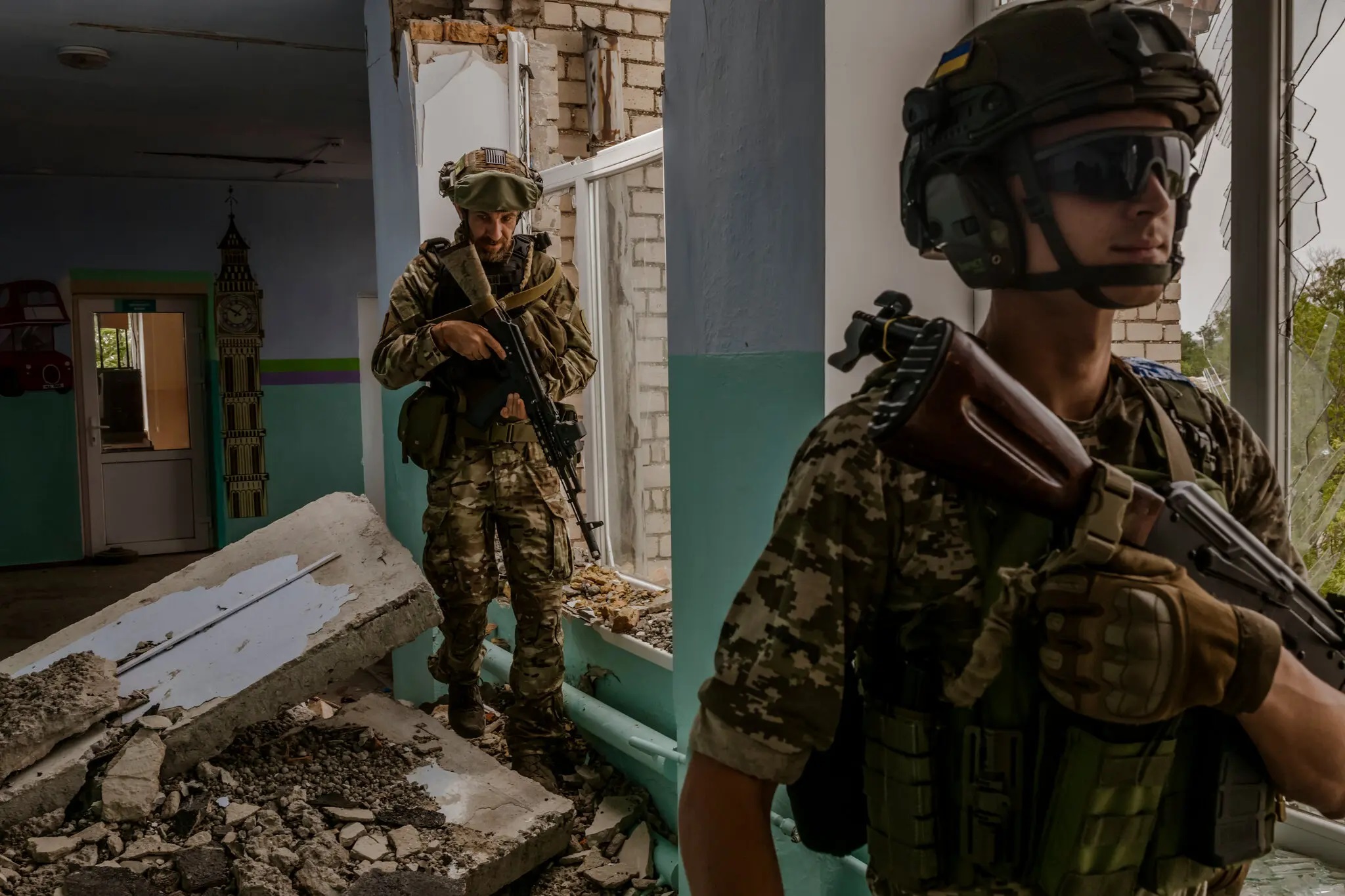 Hai người lính Ukraine tại một trường học mới bị Nga oanh tạc gần tiền tuyến Kherson - Mykolaiv. Ảnh: NY Times.