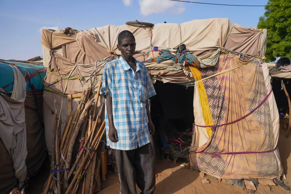 Người đàn ông NIger đứng trước căn lều dựng tạm mà anh sống cùng gia đình ở Niamey ngày 31/7. Ảnh: AP