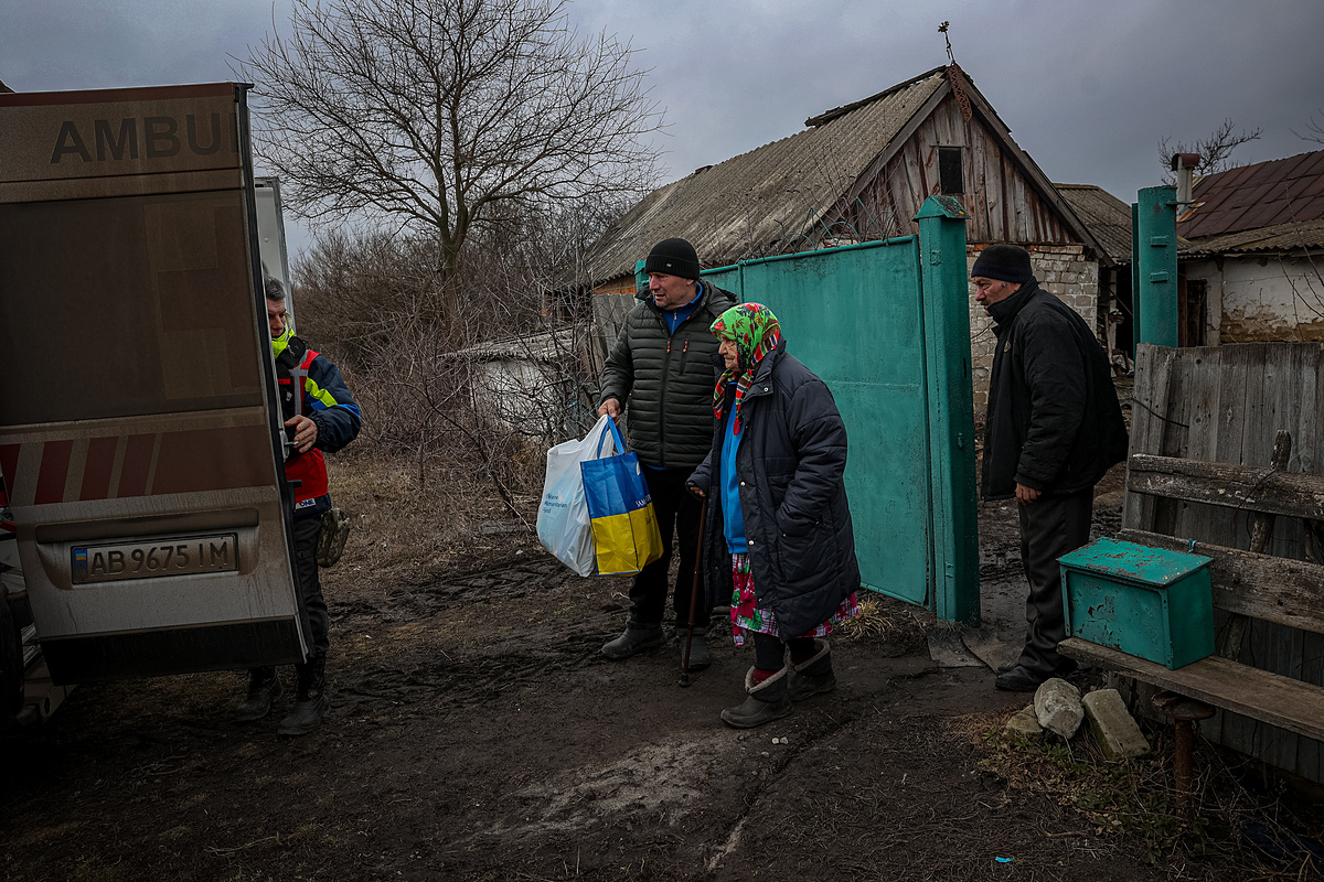 Tình nguyện viên Hội Chữ thập Đỏ giúp sơ tán cụ bà gần thành phố Kupyansk, tỉnh Kharkov hồi tháng 3. Ảnh: AFP
