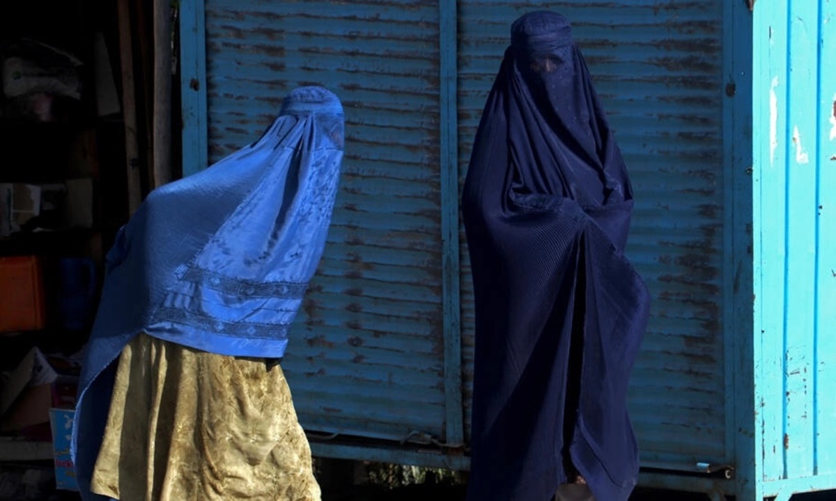 Hai phụ nữ Afghanistan trùm khăn kín cơ thể đi bộ trên đường ở quận Fayzabad, tỉnh Badakhshan, hôm 8/8. Ảnh: AFP