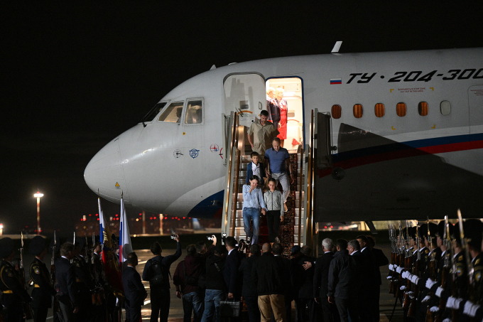 Nhóm tù nhân Nga được trả tự do rời máy bay sau khi về đến Moskva ngày 1/8. Ảnh: AFP