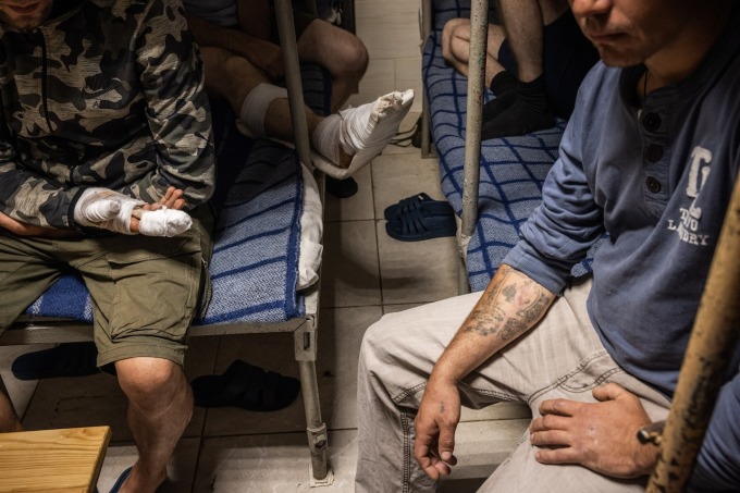 Captured Russian soldiers and border guards sit in a cell in a Ukrainian prison in northeastern Ukraine. Several wounded soldiers interviewed by The Post explained how they sustained injuries in battle before their capture. (Ed Ram for The Washington Post)