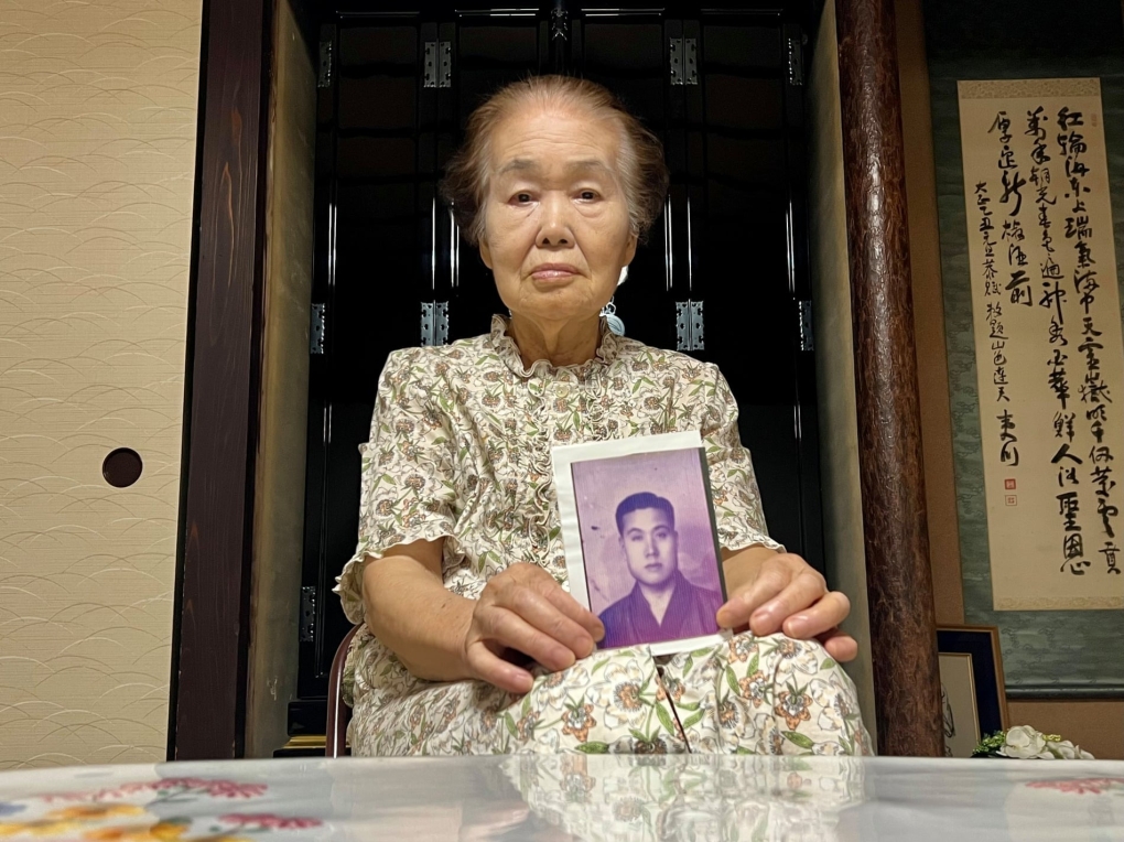 Yoshiko Niiyama, with a picture of her father. His remains were never found. Photograph: Justin McCurry/The Guardian