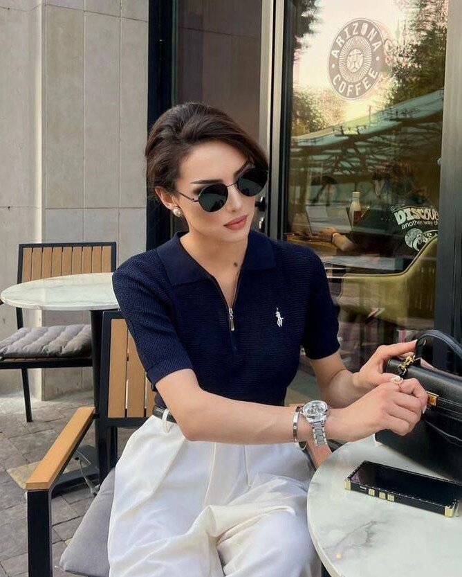 Chiếc áo polo dệt kim với cổ zip phá cách mang đến sự chỉn chu mà không gò bó. Tông xanh navy phối quần trắng tạo điểm nhấn đối lập vừa cổ điển vừa cá tính.