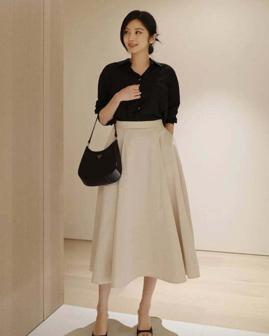 Chân váy chữ A là món đồ “bất biến” trong tủ đồ nhờ khả năng che khuyết điểm khéo léo và tạo hiệu ứng vóc dáng cân đối. Với thiết kế ôm nhẹ ở eo rồi xòe dần xuống gấu, item này giúp vòng eo trông thon hơn, đồng thời giấu gọn phần bụng và hông.
