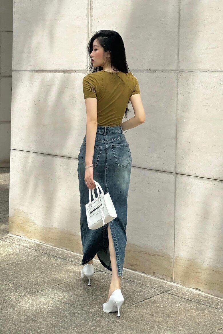 Với thiết kế dài đến mắt cá chân, chân váy denim xẻ tà tỏ ra “dễ tính” với nhiều dáng người, bởi đường xẻ khéo léo tạo hiệu ứng thon gọn và uyển chuyển.