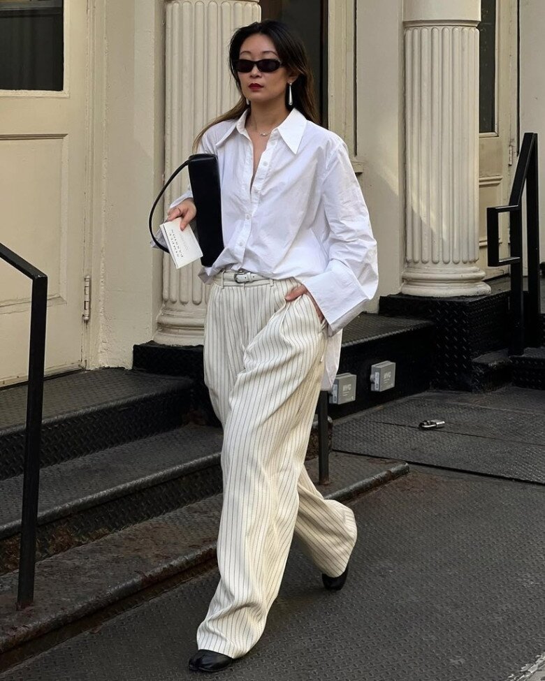 Nếu bạn muốn thêm phần chuyên nghiệp, hãy thử một chiếc sơ mi trắng dáng rộng tối giản, mix cùng quần ống rộng cạp cao – công thức hoàn hảo để vừa thanh lịch nơi công sở vừa giữ được nét năng động hiện đại.