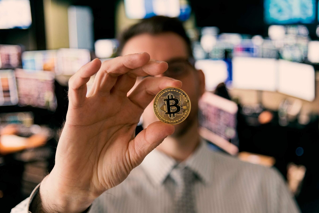 Một nhà đầu tư đang cầm biểu trưng của Bitcoin. Ảnh: CNBC