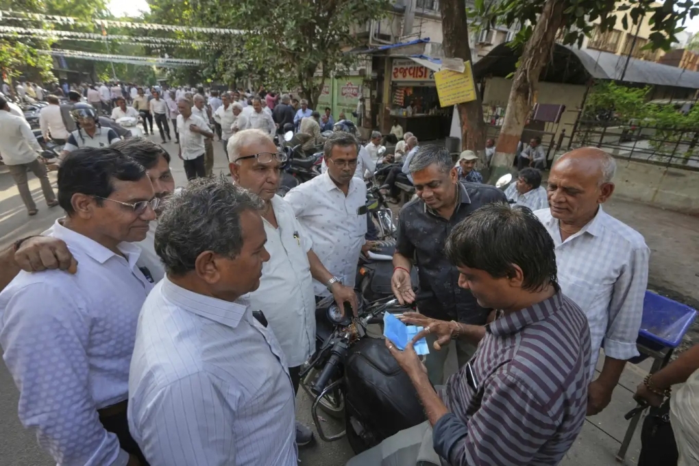 Một người lái buôn kiểm tra kim cương trên khu chợ đường phố ở Surat, ngày 14/4. Ảnh: AP