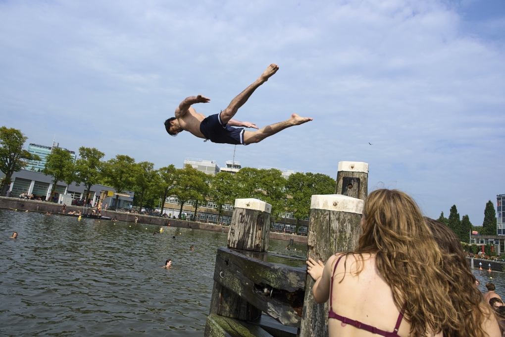 Người dân bơi lội giải nhiệt giữa ngày hè nắng nóng ở Amsterdam hôm 13/8. Ảnh: AP