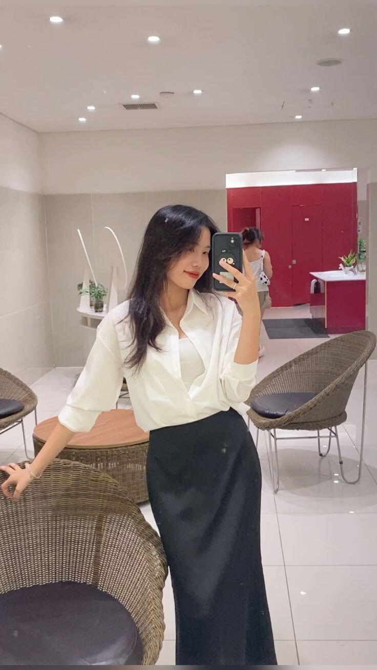 Chân váy lụa midi dáng rủ mềm mại kết hợp áo sơ mi gọn gàng cho phong cách công sở thanh lịch.