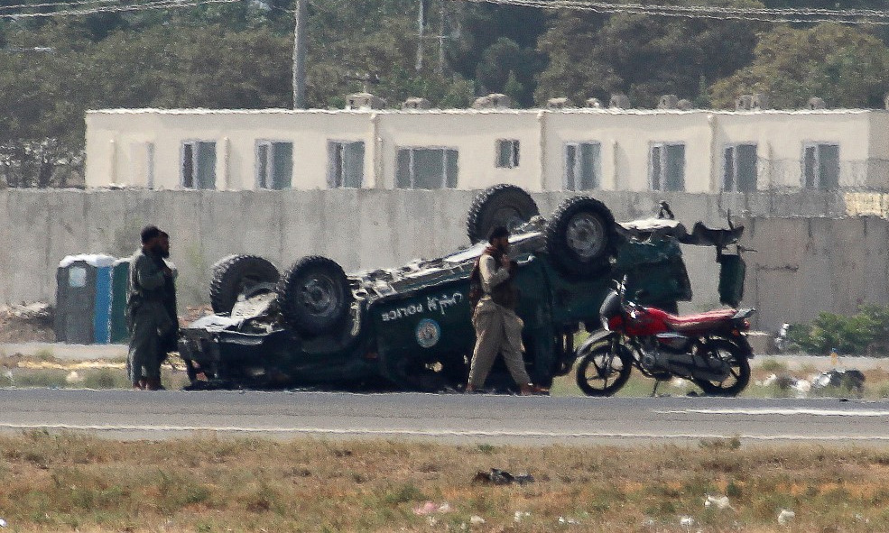 Các tay súng Taliban xung quanh xe cảnh sát bị lật ở sân bay Kabul hôm 31/8. Ảnh: AFP.