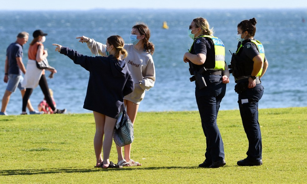 Cảnh sát nói chuyện với người dân trên bãi biển ở thành phố Melbourne, Australia, hôm 2/9. Ảnh: AFP.