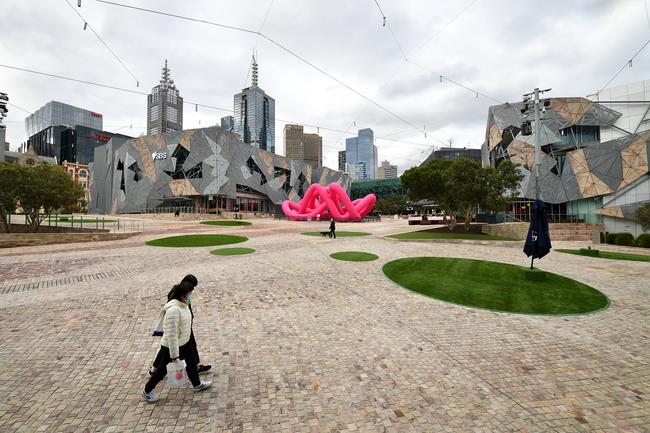 People are seen wearing face masks at Federation Square in Melbourne.