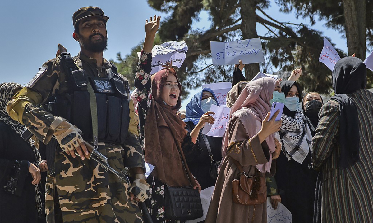Một tay súng Taliban đứng cạnh nhóm phụ nữ biểu tình trước đại sứ quán Pakistan ở Afghanistan ngày 7/9. Ảnh: AFP.