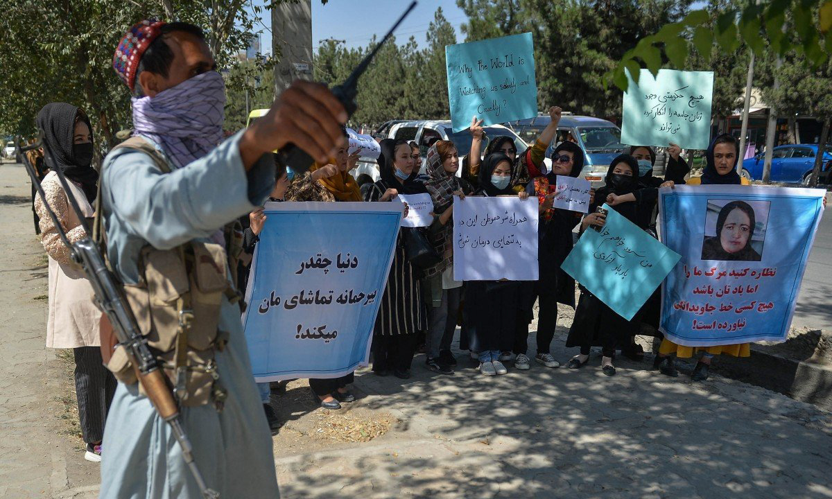 Một tay súng Taliban đứng giám sát nhóm phụ nữ biểu tình ở Kabul, Afghanistan hôm 8/9. Ảnh: AFP.