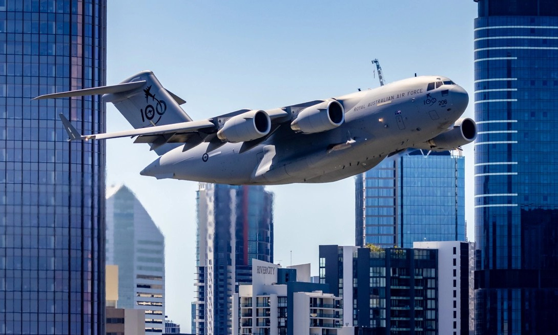 Chiếc C-17A bay giữa các tòa nhà chọc trời ở Brisbane, Australia, hôm 23/9. Ảnh: James Woodrow.