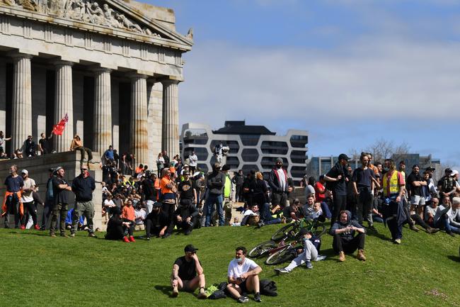 Protesters sit on the lawn at the Shrine of Remembrance.